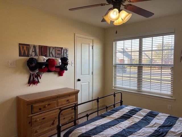 6303 112th Street Lubbock, TX 79424 - Photo 14 of 18 a bedroom with a bed and a chandelier