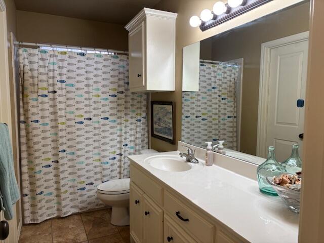 6303 112th Street Lubbock, TX 79424 - Photo 15 of 18 a bathroom with a sink a toilet and shower curtain
