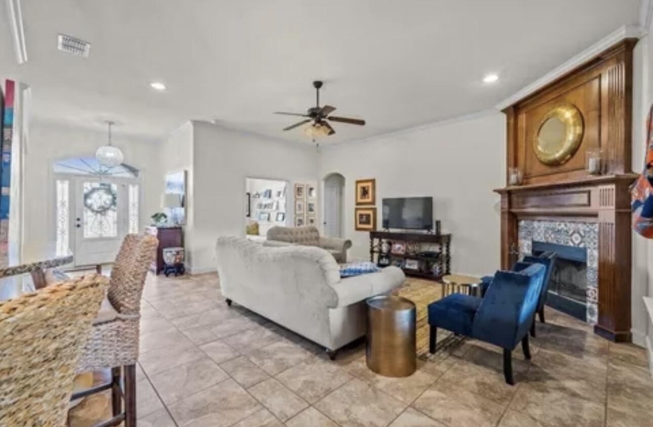 6303 112th Street Lubbock, TX 79424 - Photo 4 of 18 a living room with furniture a fireplace and a flat screen tv