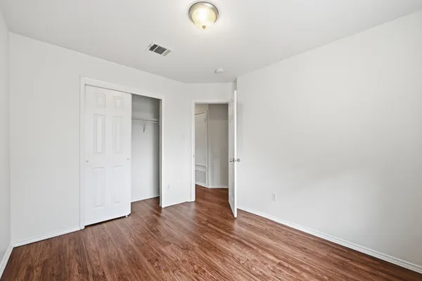a view of an empty room with wooden floor