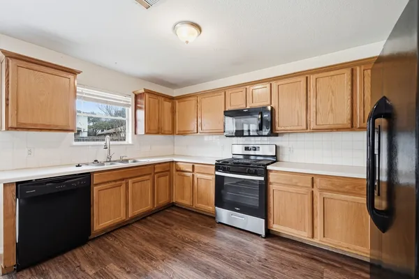 a kitchen with stainless steel appliances granite countertop a sink stove and refrigerator