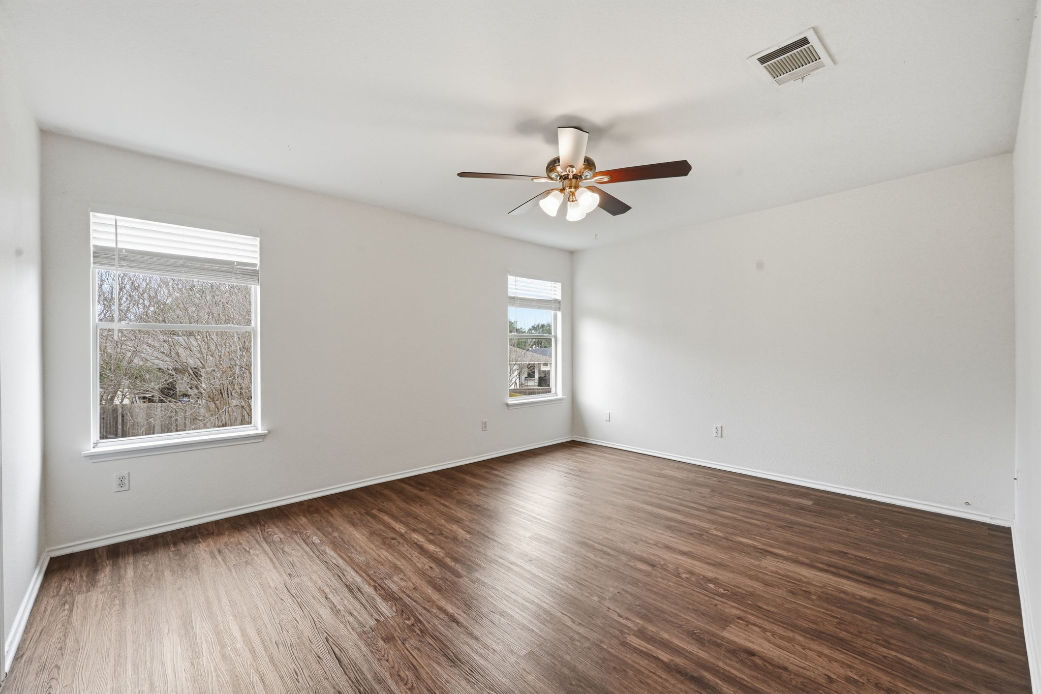 11145 Franklins Tale Loop Austin, TX 78748 - Photo 6 of 31 a view of an empty room with a window and wooden floor