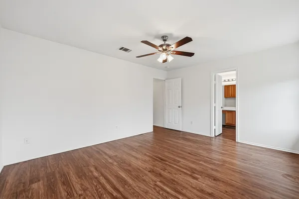 a view of an empty room with wooden floor