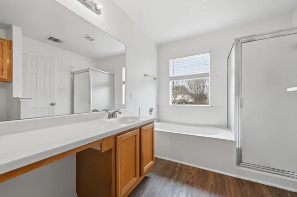 a bathroom with a sink a large mirror and a bathtub