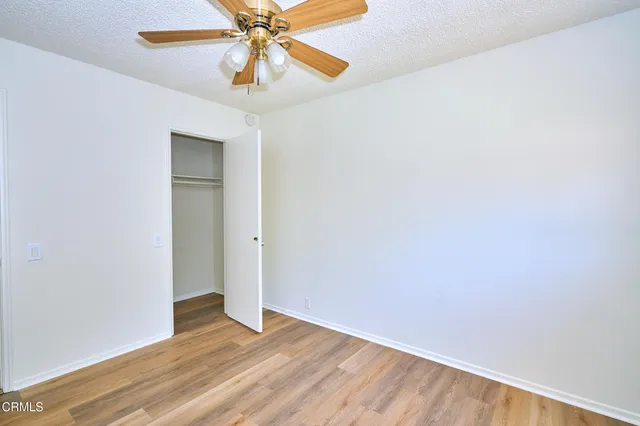 an empty room with a window and a fan