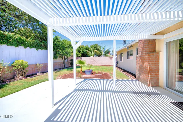 a view of a house with backyard and sitting area