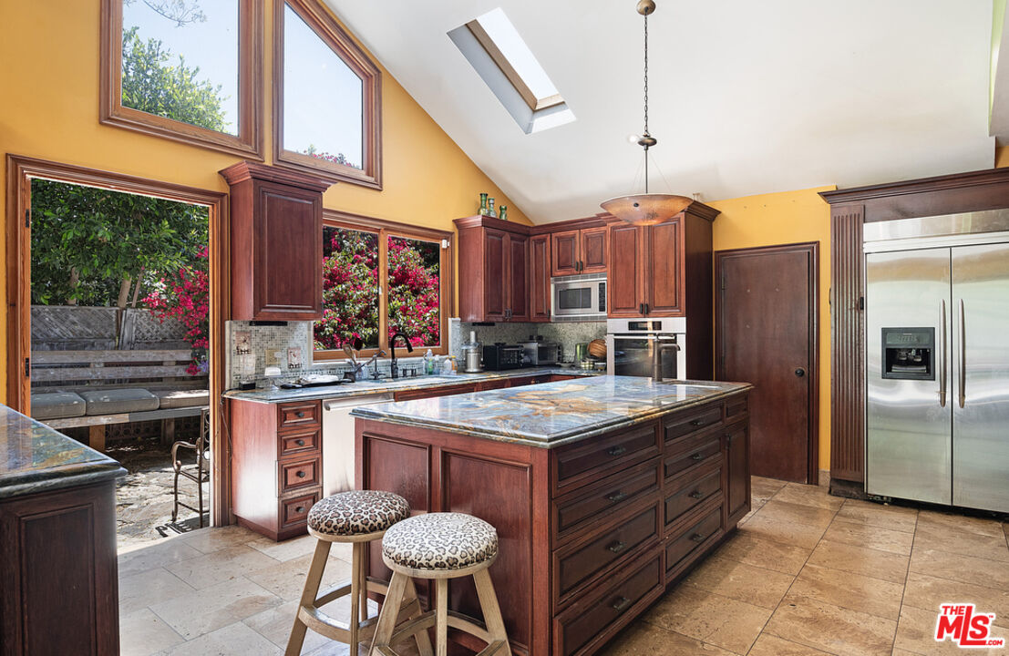 1260 Roscomare Road Los Angeles, CA 90077 - Photo 27 of 75 a kitchen with stainless steel appliances granite countertop a sink and a refrigerator