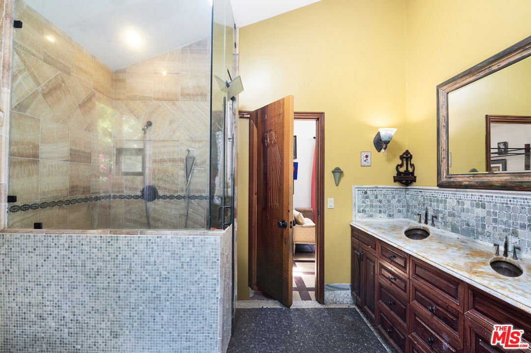 1260 Roscomare Road Los Angeles, CA 90077 - Photo 39 of 75 a spacious bathroom with a granite countertop sink a mirror and shower