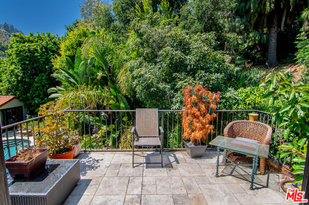1260 Roscomare Road Los Angeles, CA 90077 - Photo 67 of 75 a backyard of a house with table and chairs potted plants