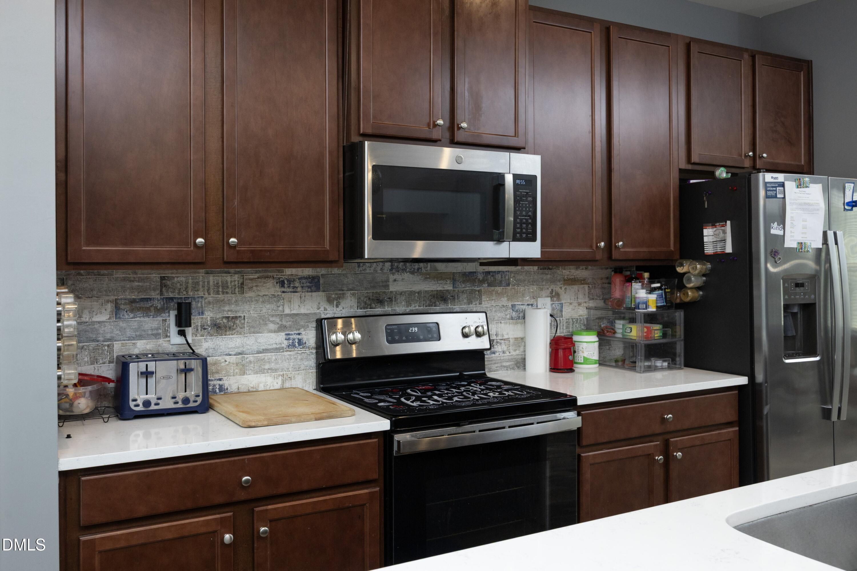 8716 Red Canyon Way Raleigh, NC 27616 - Photo 13 of 36 a kitchen with granite countertop wooden cabinets and stainless steel appliances