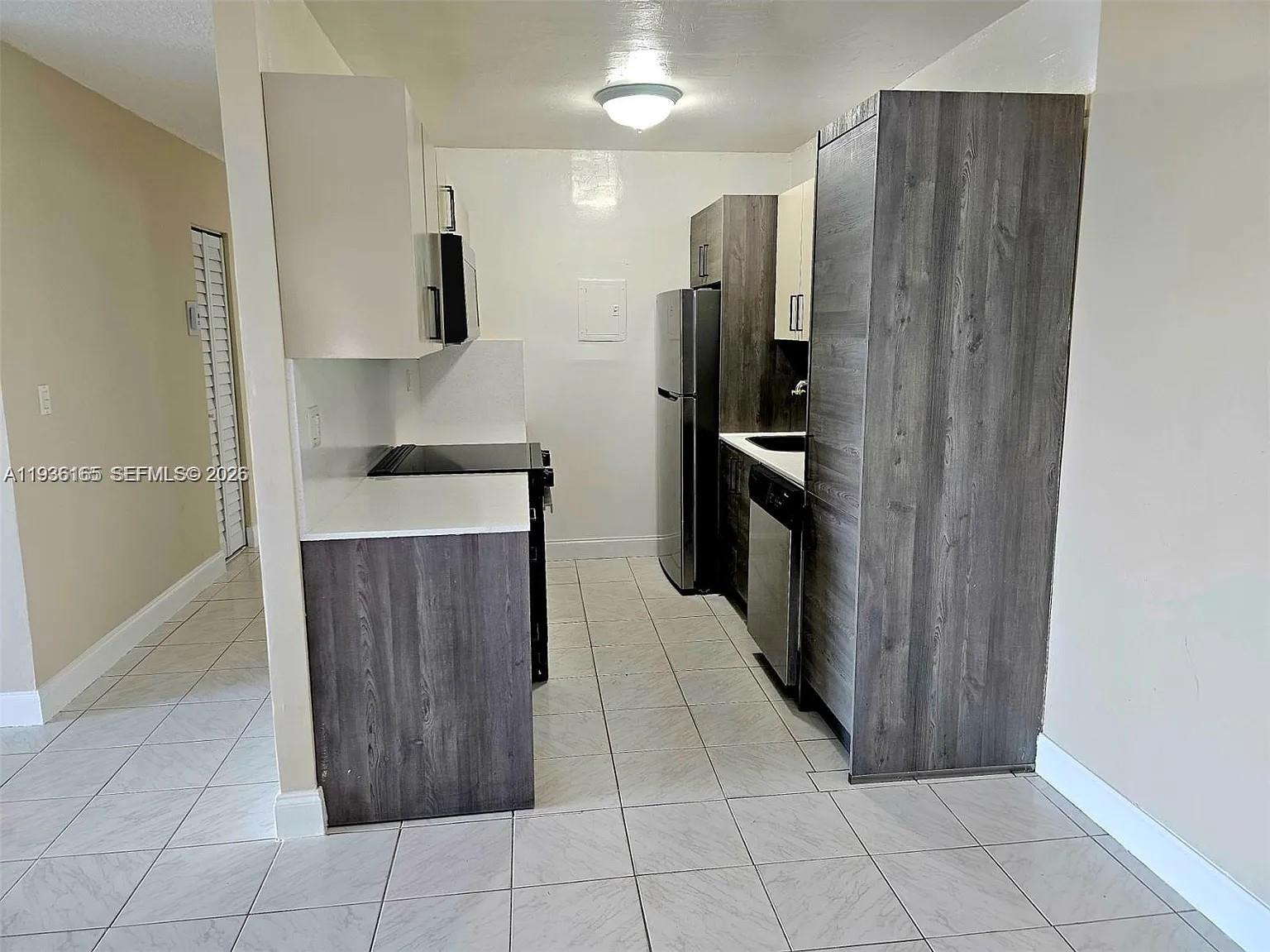 5501 Northwest 7th Street, Unit E302 Miami, FL 33126 - Photo 3 of 17 a kitchen with stainless steel appliances a refrigerator and a sink