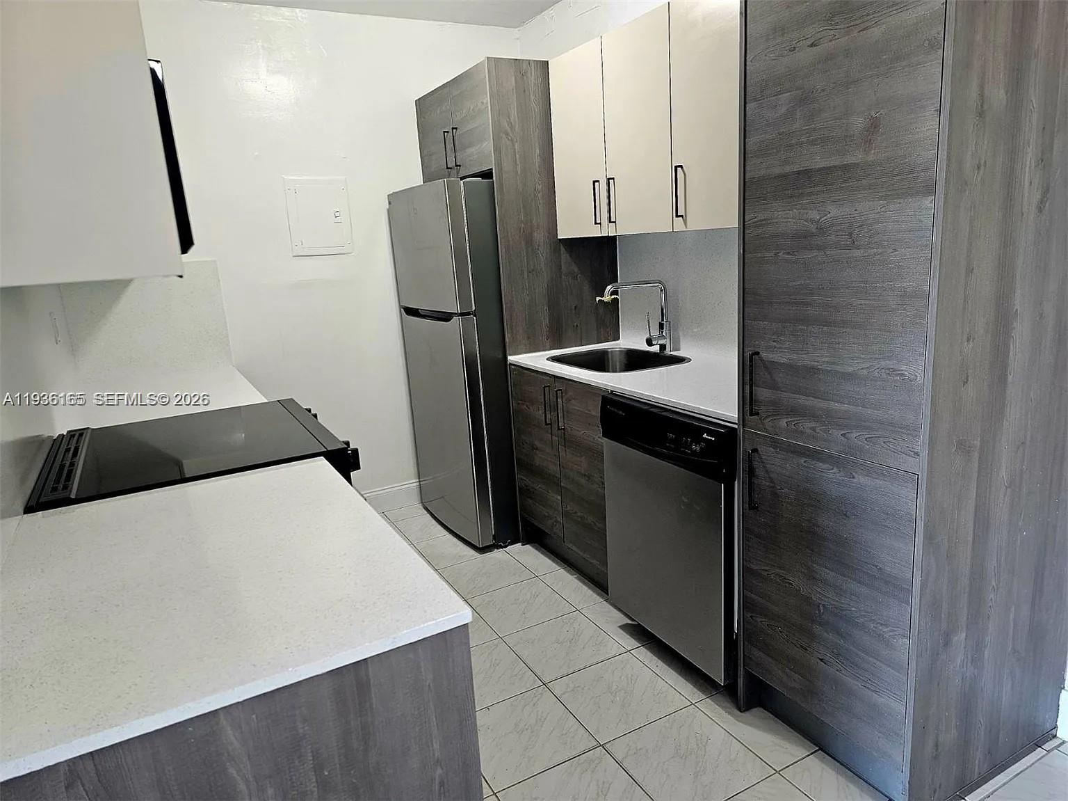 5501 Northwest 7th Street, Unit E302 Miami, FL 33126 - Photo 4 of 17 a kitchen with stainless steel appliances a refrigerator sink and stove