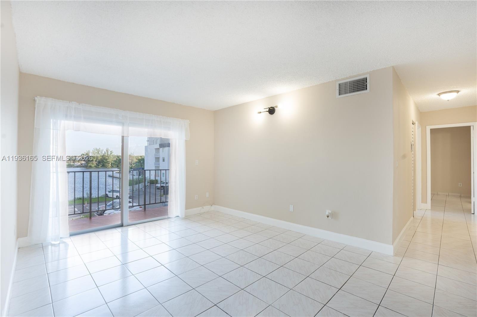 5501 Northwest 7th Street, Unit E302 Miami, FL 33126 - Photo 5 of 17 a view of an empty room and window