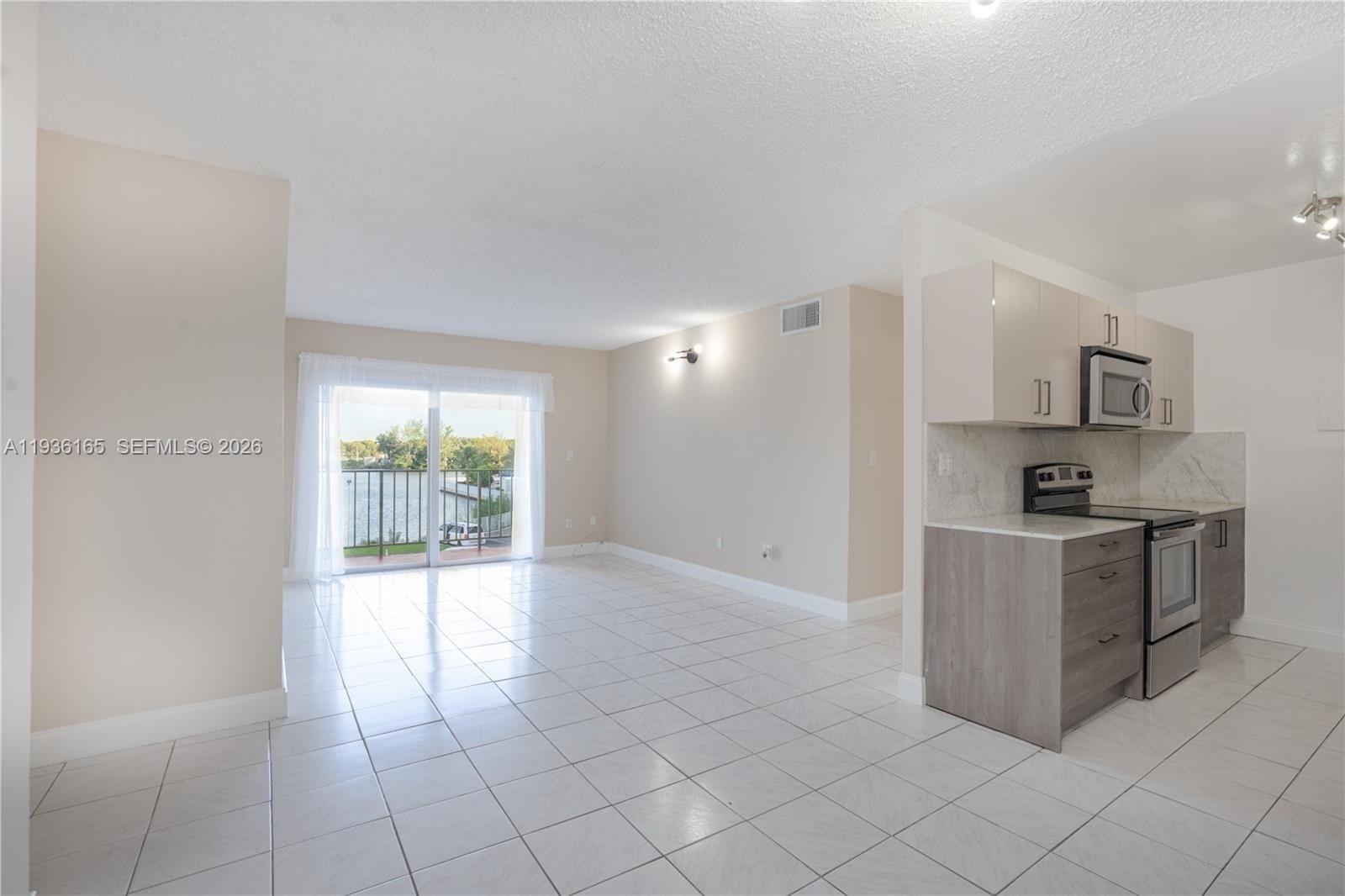 5501 Northwest 7th Street, Unit E302 Miami, FL 33126 - Photo 6 of 17 a kitchen with stainless steel appliances a refrigerator and a stove top oven