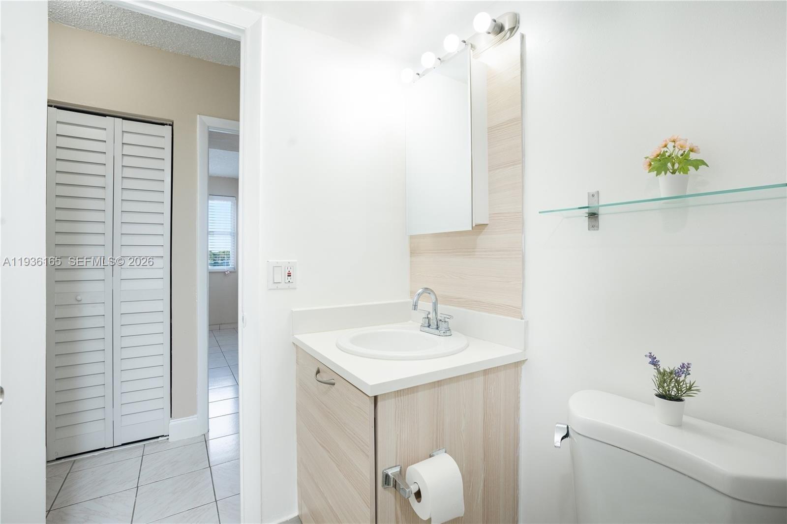 5501 Northwest 7th Street, Unit E302 Miami, FL 33126 - Photo 10 of 17 a bathroom with a sink a toilet and shower