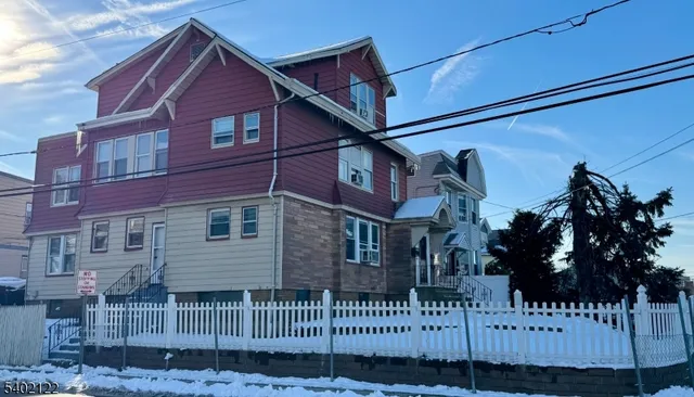 a view of a house with a small yard and wooden fence
