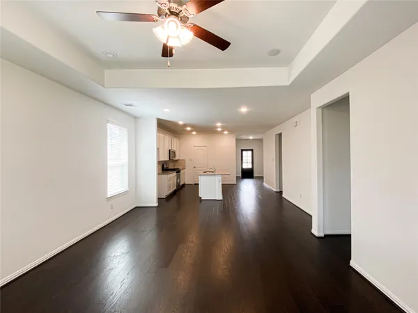 a view of a room with wooden floor staircase and a kitchen