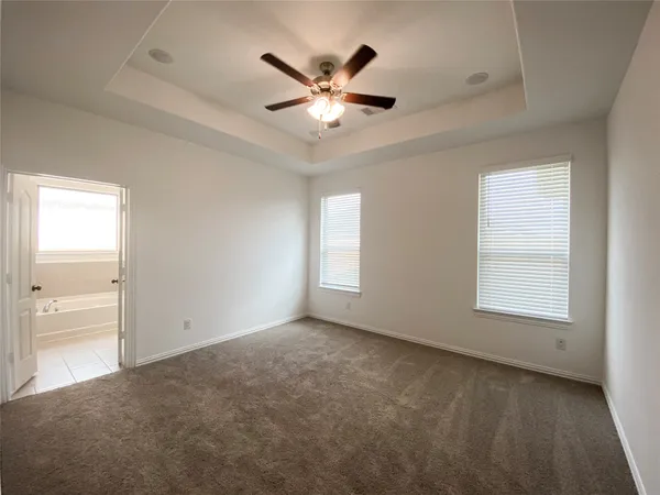 a view of an empty room with a ceiling fan and window
