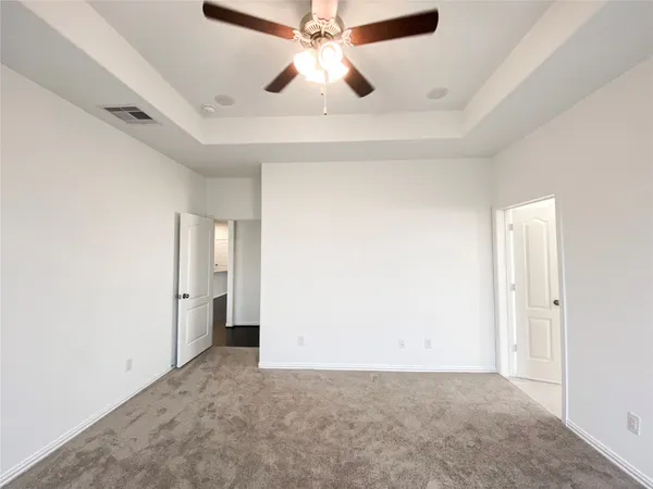 an empty room with chandelier fan