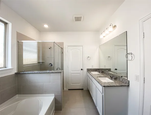 a bathroom with a granite countertop sink mirror and a bathtub