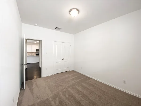 an empty room with closet and windows