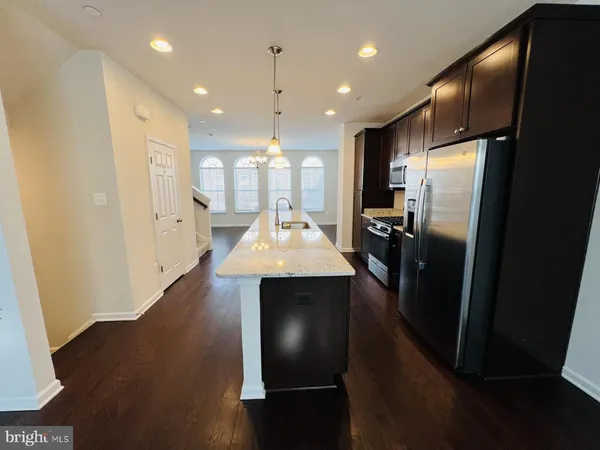 a kitchen with refrigerator a sink and chairs