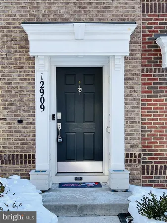 a front view of a house with a tree