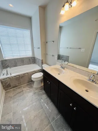 a spacious bathroom with a double vanity sink toilet and shower