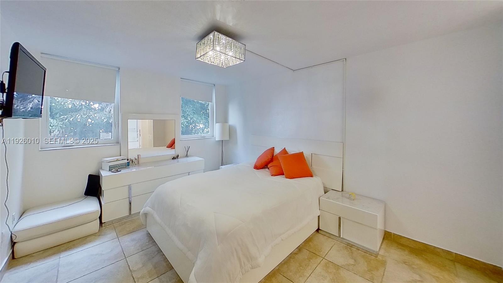 1666 West Avenue, Unit 312 Miami Beach, FL 33139 - Photo 1 of 42 a bedroom with a bed and a chandelier