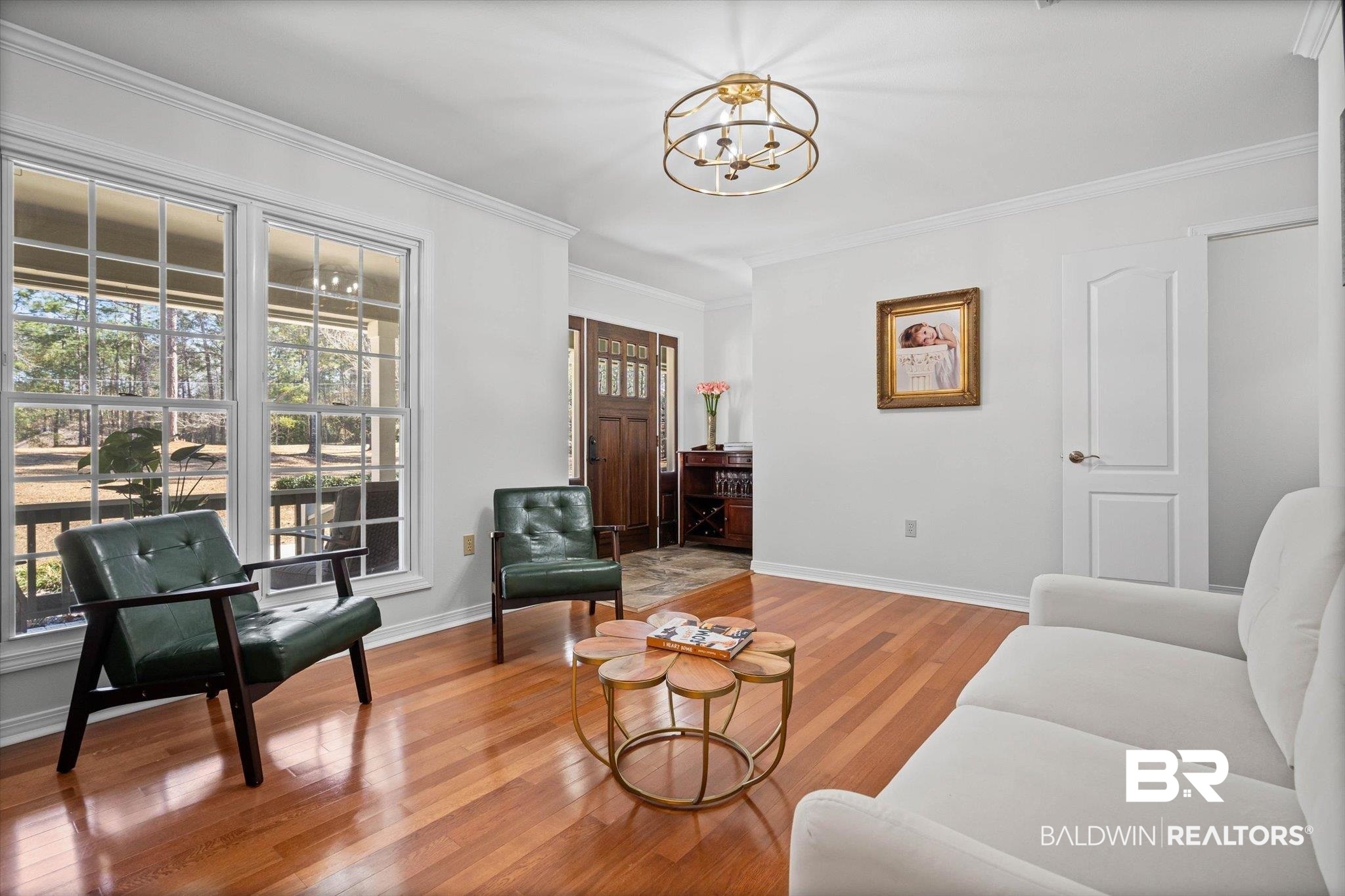 31369 Blakeley Way Daphne, AL 36527 - Photo 3 of 38 Living room featuring light wood finished floors, ornamental molding, and a chandelier
