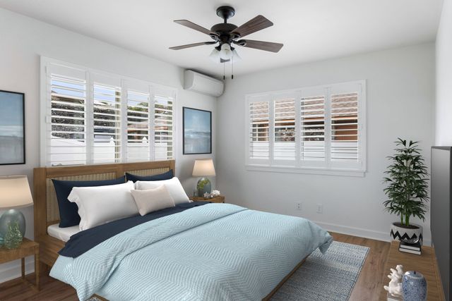 a bedroom with a large bed and a chandelier fan
