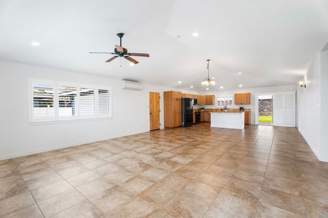 a view of a livingroom with a stove wooden cabinets and a chandelier