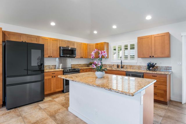 a kitchen with stainless steel appliances granite countertop a sink a stove and a refrigerator
