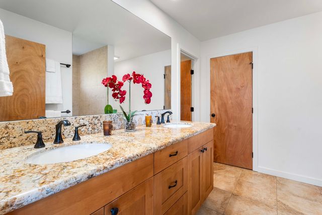a bathroom with a granite countertop sink and a mirror