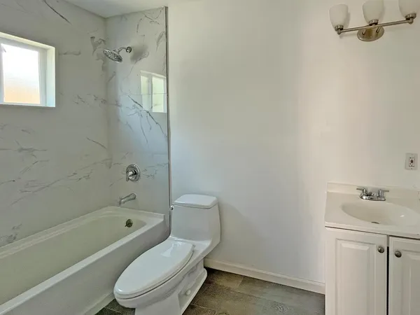 a white toilet sitting next to a bath tub