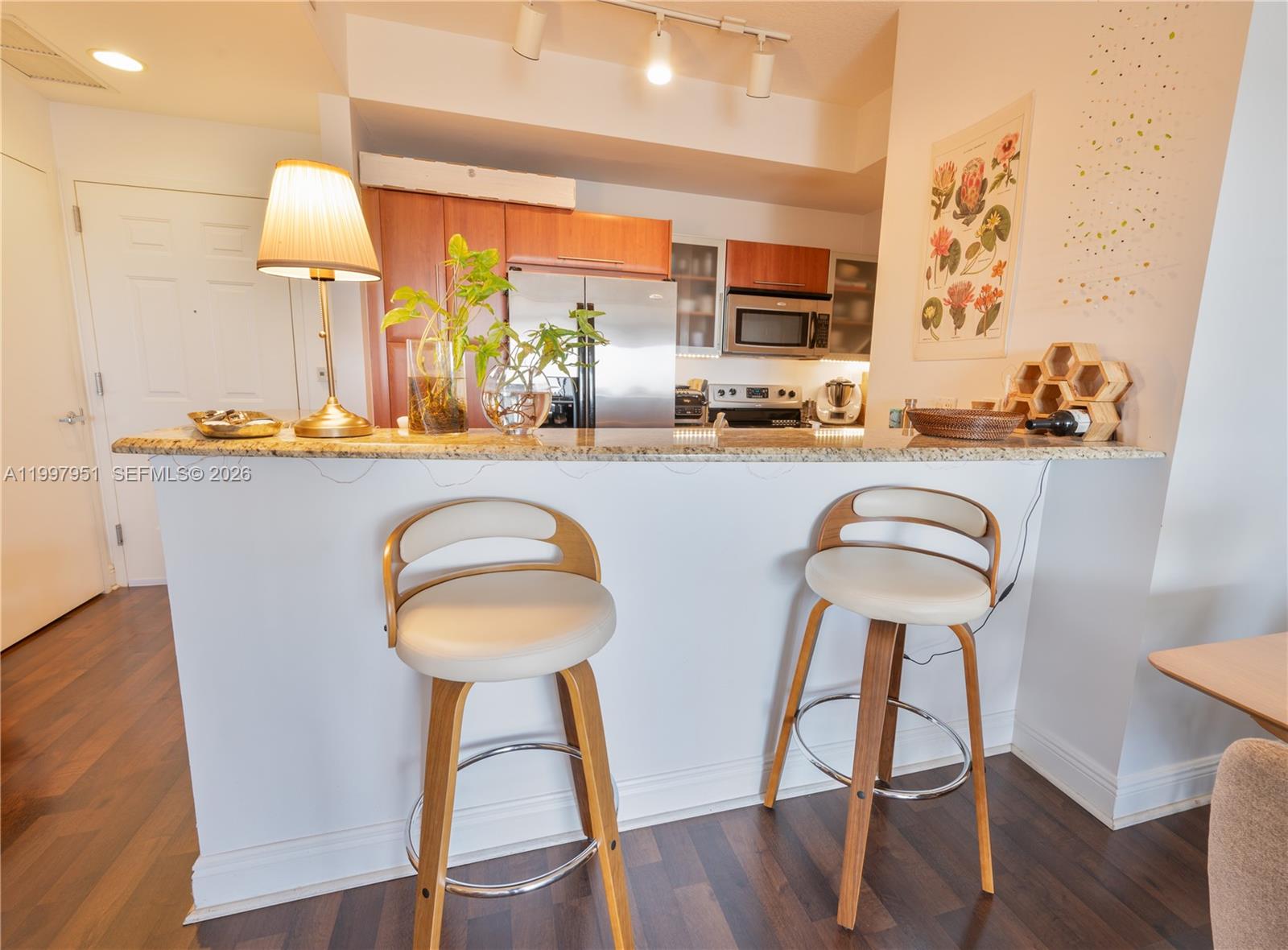 3232 Southwest 22nd Terrace, Unit 607 Miami, FL 33145 - Photo 4 of 20 a kitchen with sink a table and chairs with wooden floor