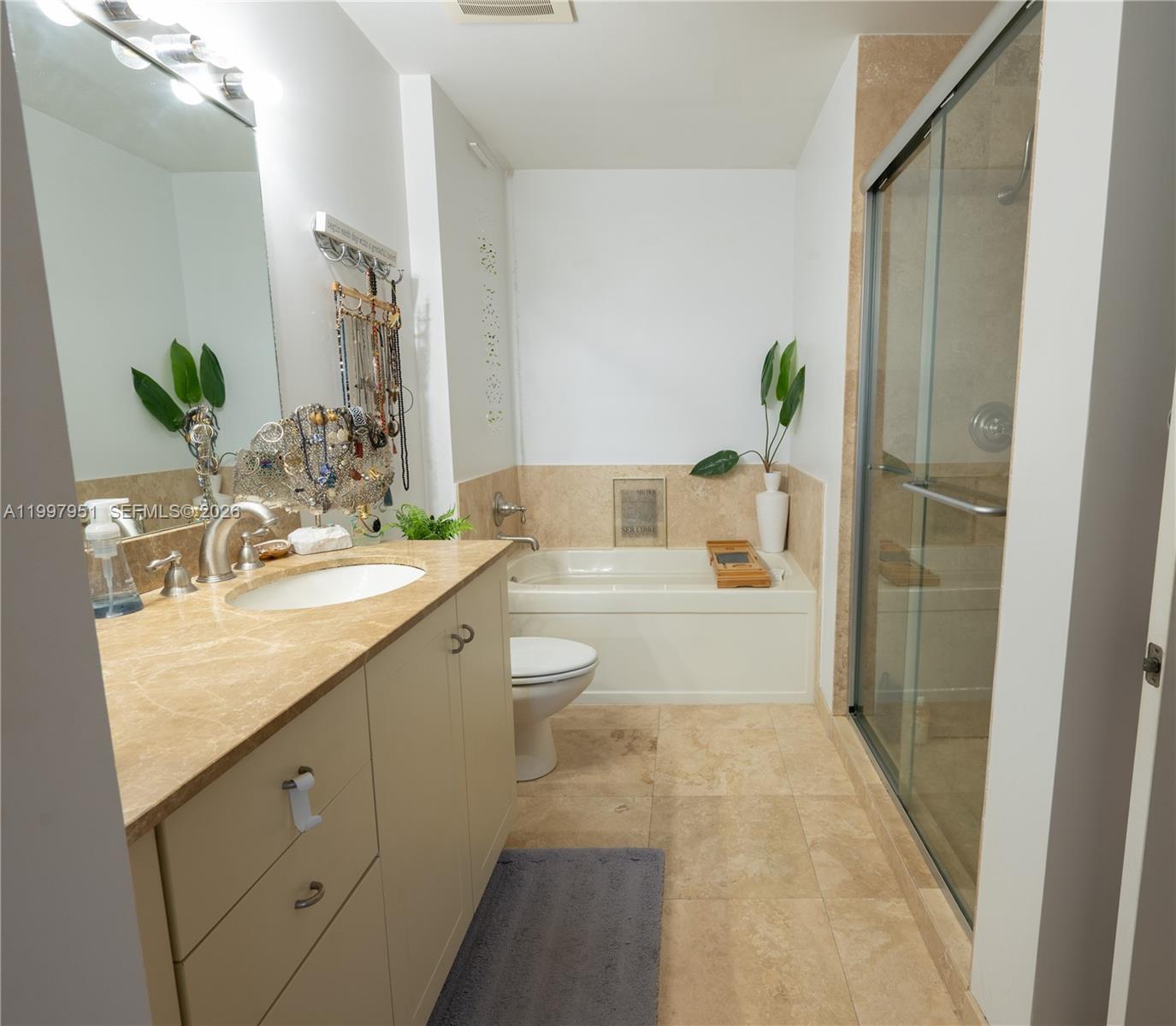 3232 Southwest 22nd Terrace, Unit 607 Miami, FL 33145 - Photo 10 of 20 a spacious bathroom with a granite countertop sink a toilet and shower