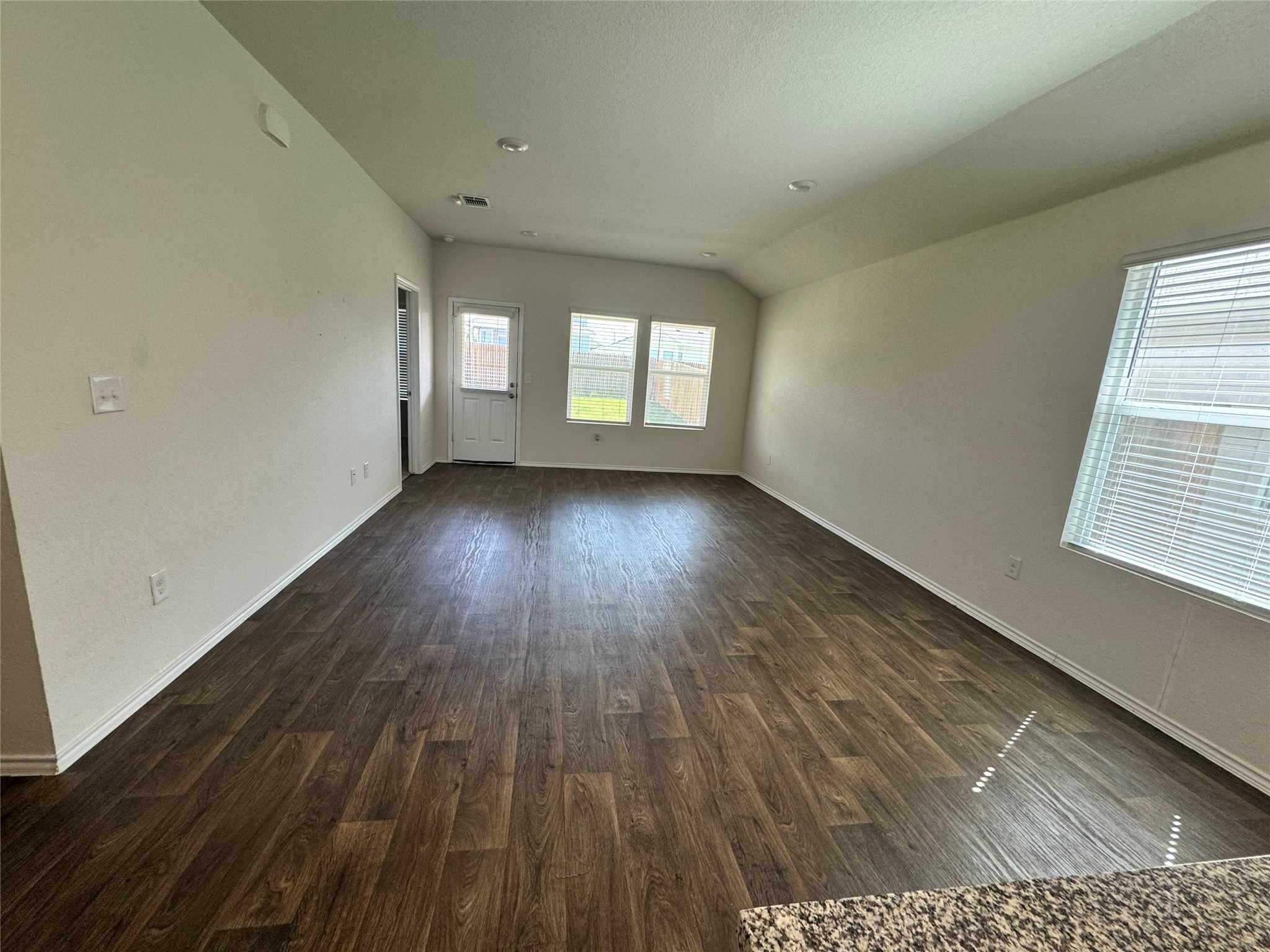 11820 Rush Lane Elgin, TX 78621 - Photo 27 of 31 A versatile living area features sleek wood-look flooring and ample natural light through well-placed windows.