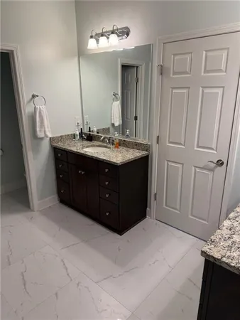 a bathroom with a granite countertop sink and a mirror
