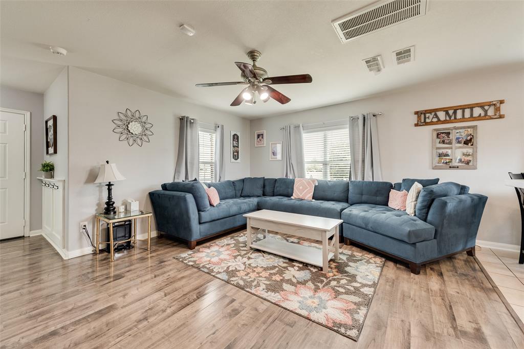 149 Cattlemans Creek Road Newark, TX 76071 - Photo 3 of 39 Living room with laminate flooring, lots of natural light and ceiling fan at 149 Cattlemans Creek Rd in the Chisholm Springs neighborhood in Newark, TX 76071