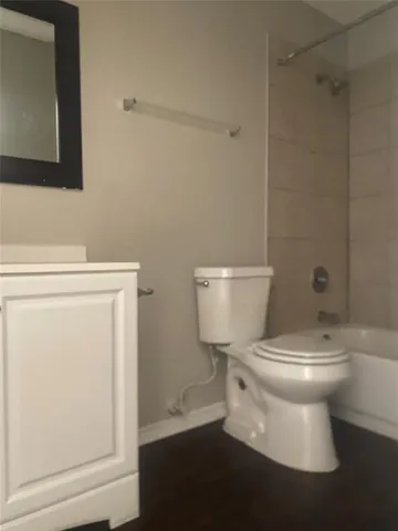 a white toilet sitting next to a bath tub