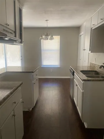 a view of a kitchen with a sink dishwasher a fireplace with wooden floor