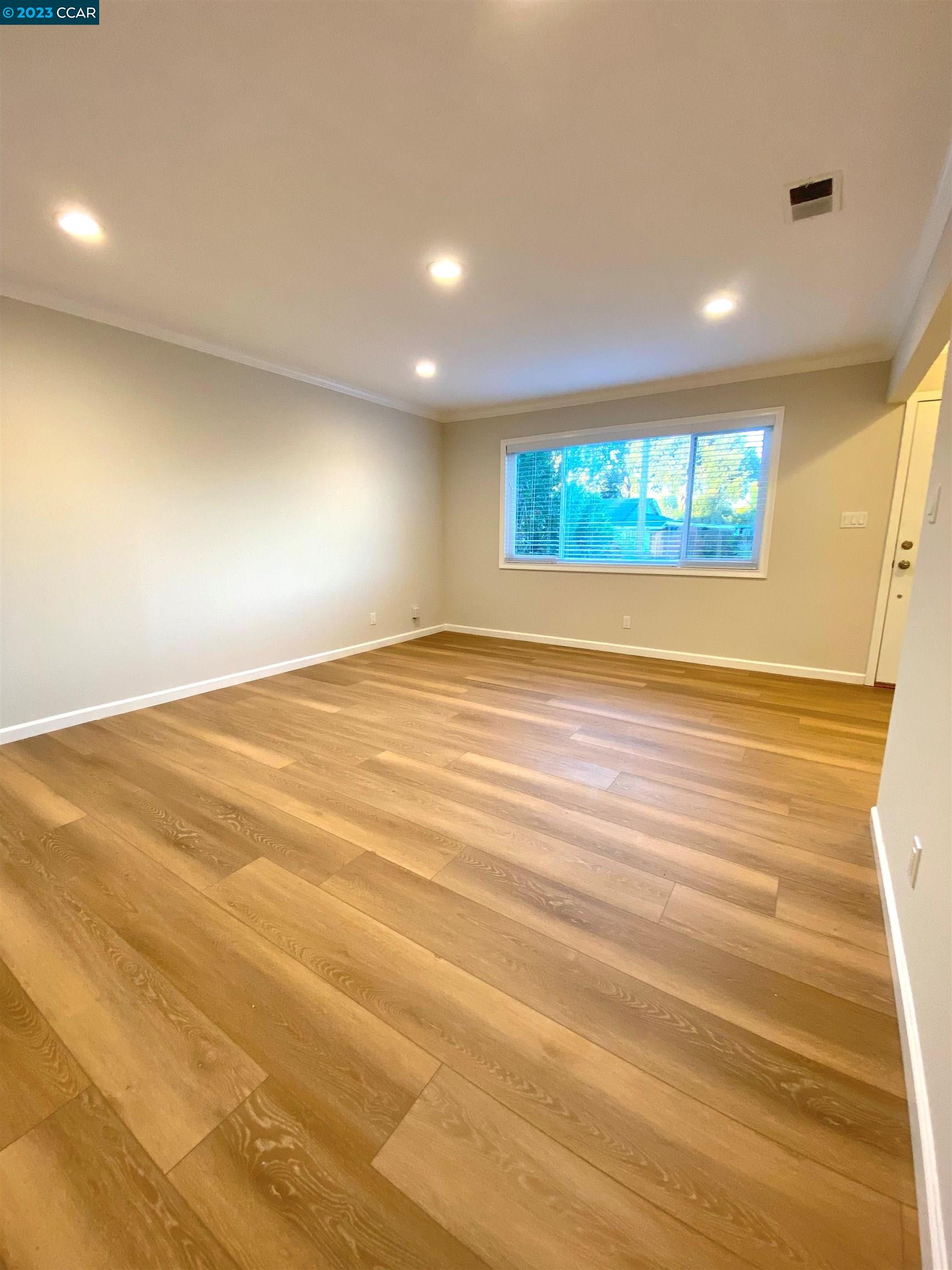 959 Duar Drive Concord, CA 94518 - Photo 2 of 14 an empty room with wooden floor and windows