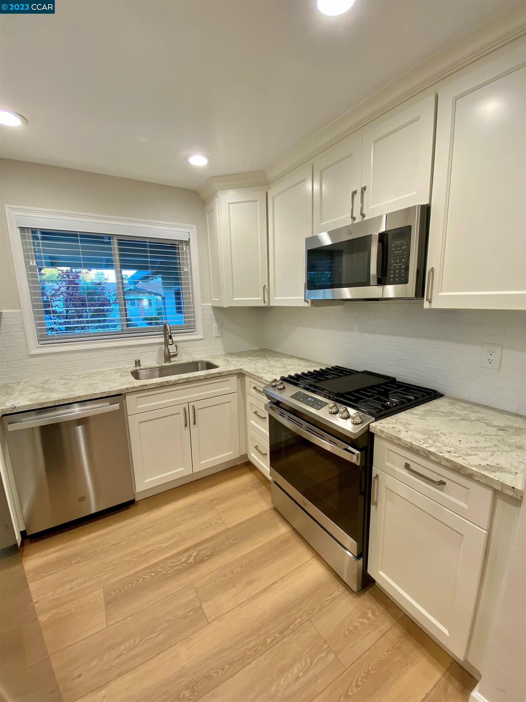 959 Duar Drive Concord, CA 94518 - Photo 3 of 14 a kitchen with stainless steel appliances a stove microwave and sink