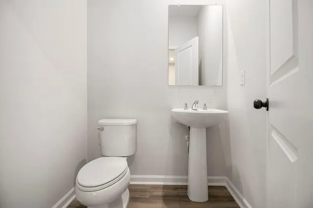 a bathroom with a toilet a sink and mirror