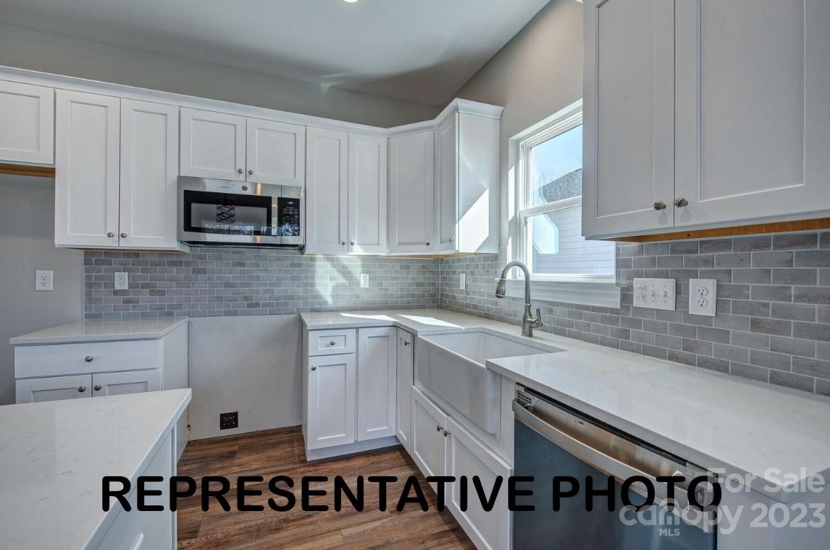 529 Blacksnake Road Stanley, NC 28164 - Photo 10 of 16 a kitchen with stainless steel appliances granite countertop a sink a stove a microwave and cabinets