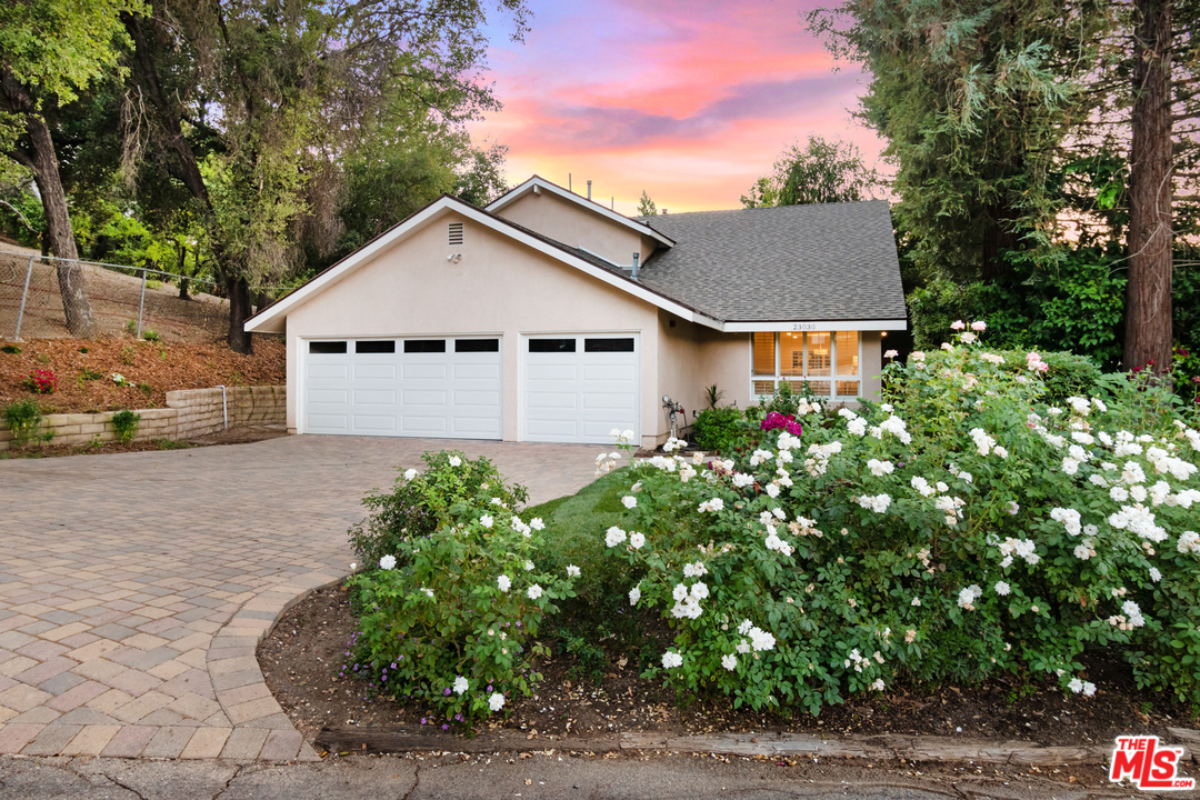 23030 Humming Bird Way Calabasas, CA 91302 - Photo 1 of 32 a view of a white house with a small yard and large tree