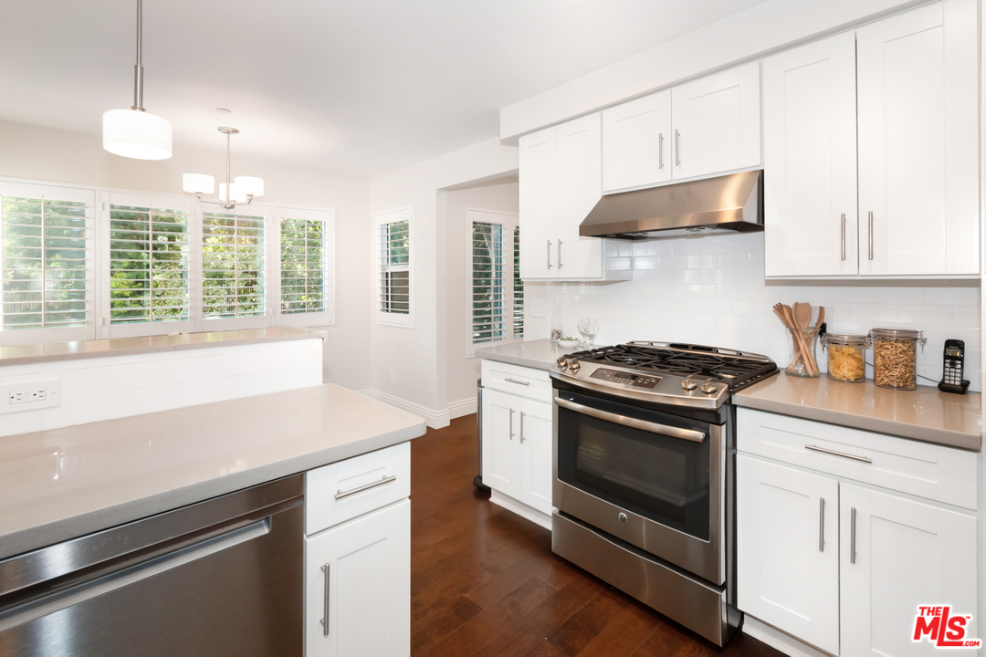 23030 Humming Bird Way Calabasas, CA 91302 - Photo 13 of 32 a kitchen with stainless steel appliances a sink a stove and a window