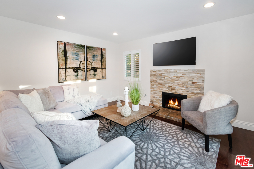23030 Humming Bird Way Calabasas, CA 91302 - Photo 16 of 32 a living room with furniture a flat screen tv and a fireplace