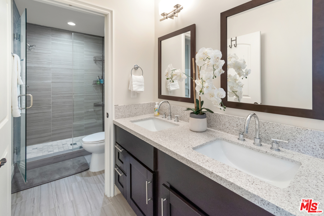 23030 Humming Bird Way Calabasas, CA 91302 - Photo 20 of 32 a bathroom with a granite countertop sink a toilet and shower